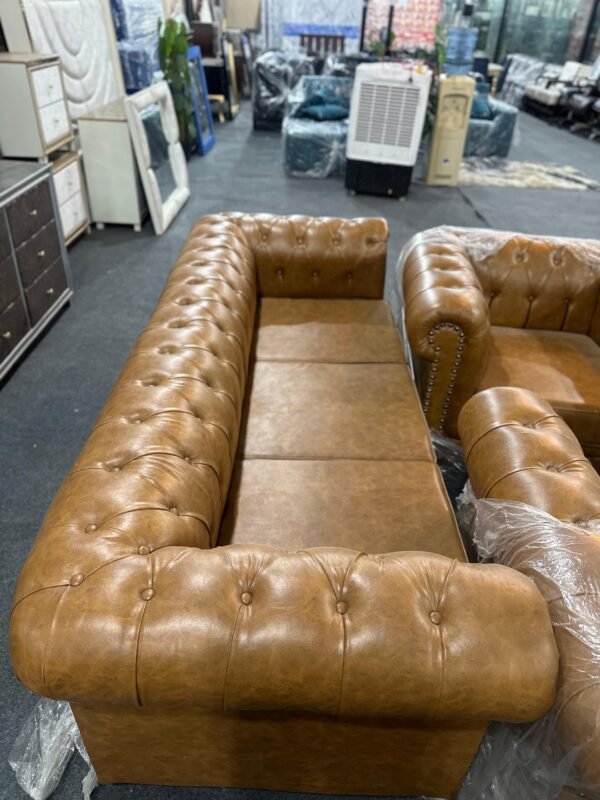 Rixin brown three-seater Chesterfield-style sofa with tufted design and faux leather finish, available at Islamabad Auctioneers.
